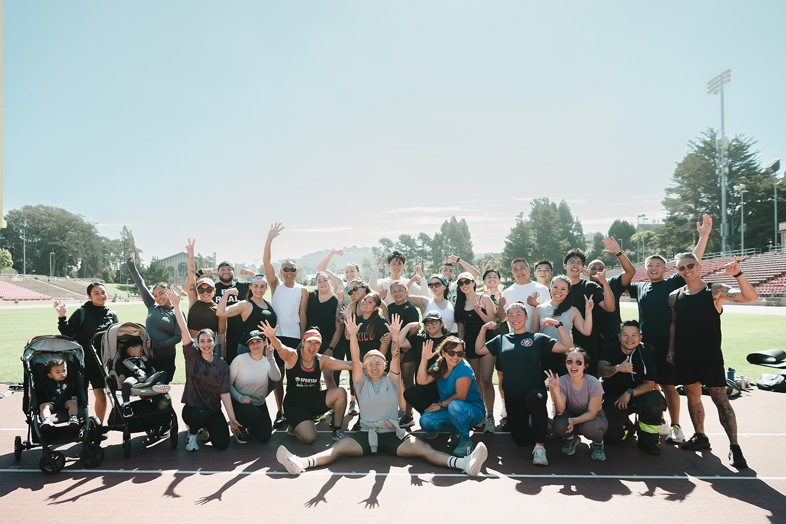 Nanstop Fitness community group celebrating together on a track after an outdoor bootcamp